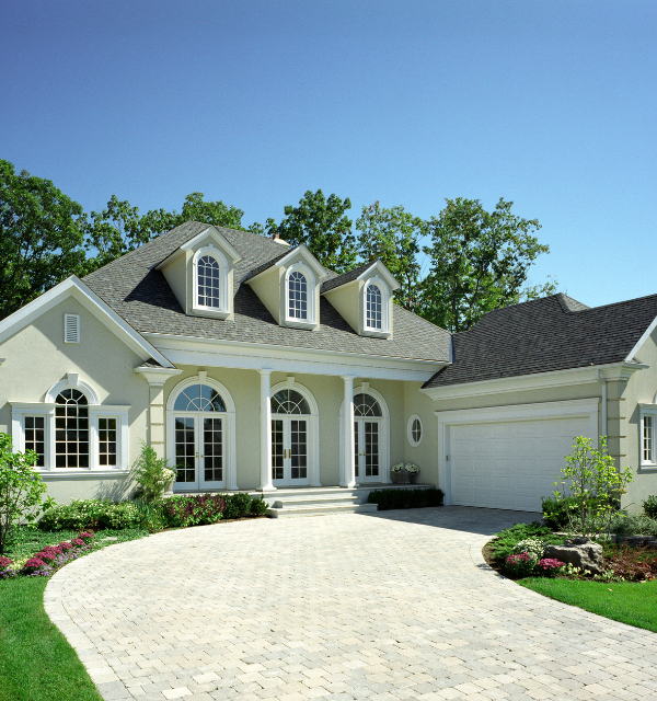 Traditional home with dormer windows and a landscaped front entrance.
